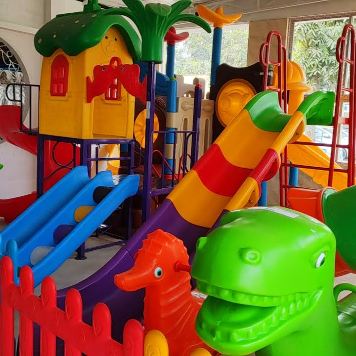 A vibrant playground featuring a slide and a dinosaur offers a fun-filled environment for children to enjoy.