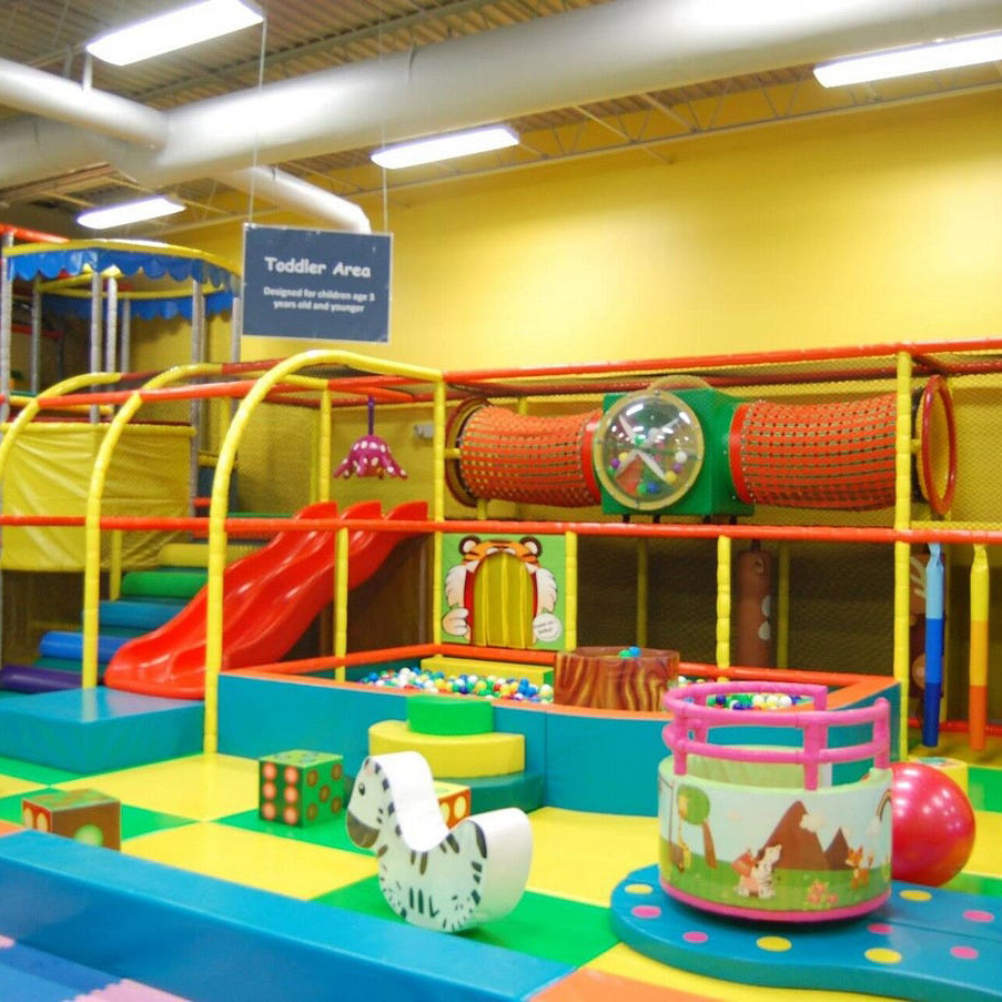 A playground with a colorful K square edutainment slide, swings, and climbing equipment.