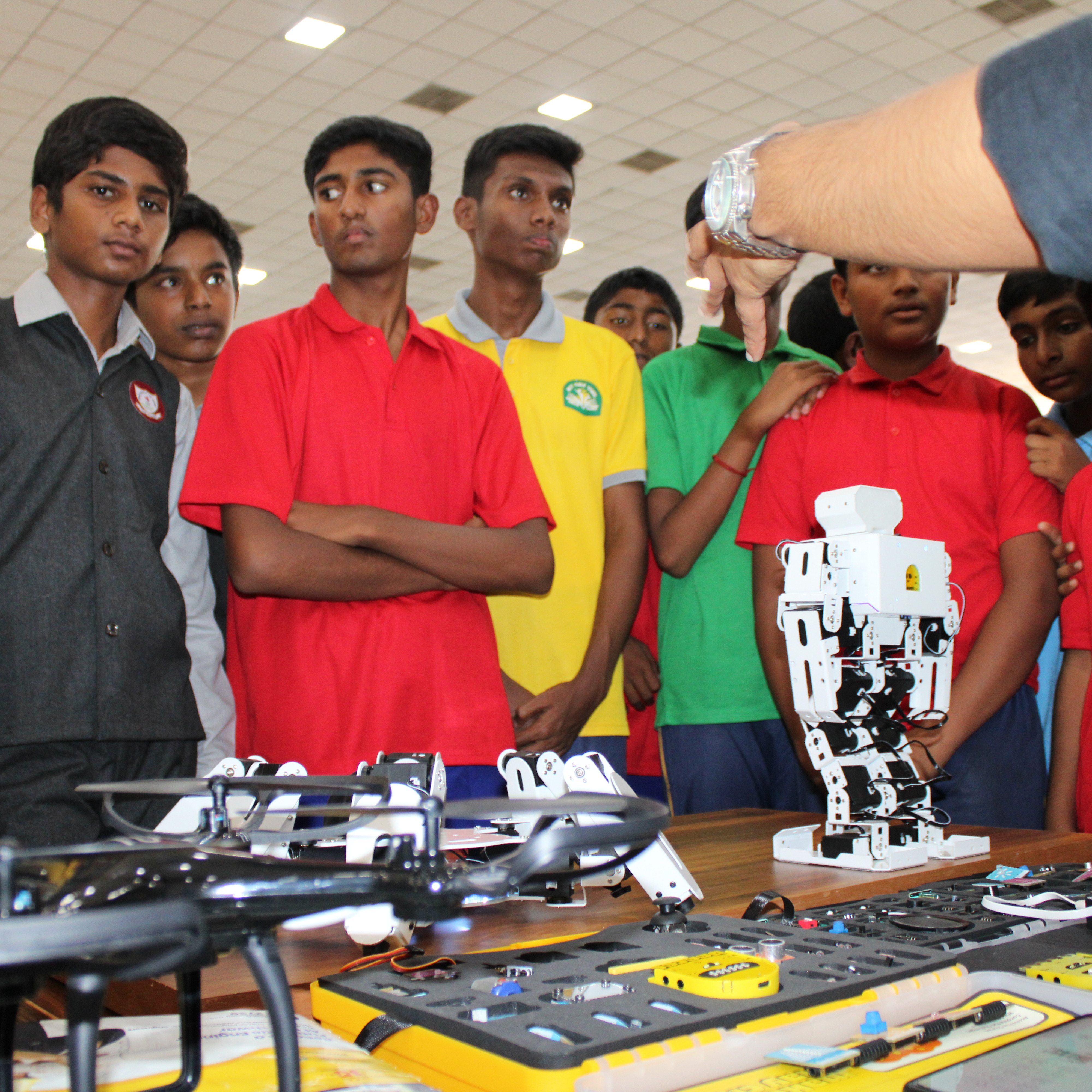 A group of boys standing around a table engaged in conversation.