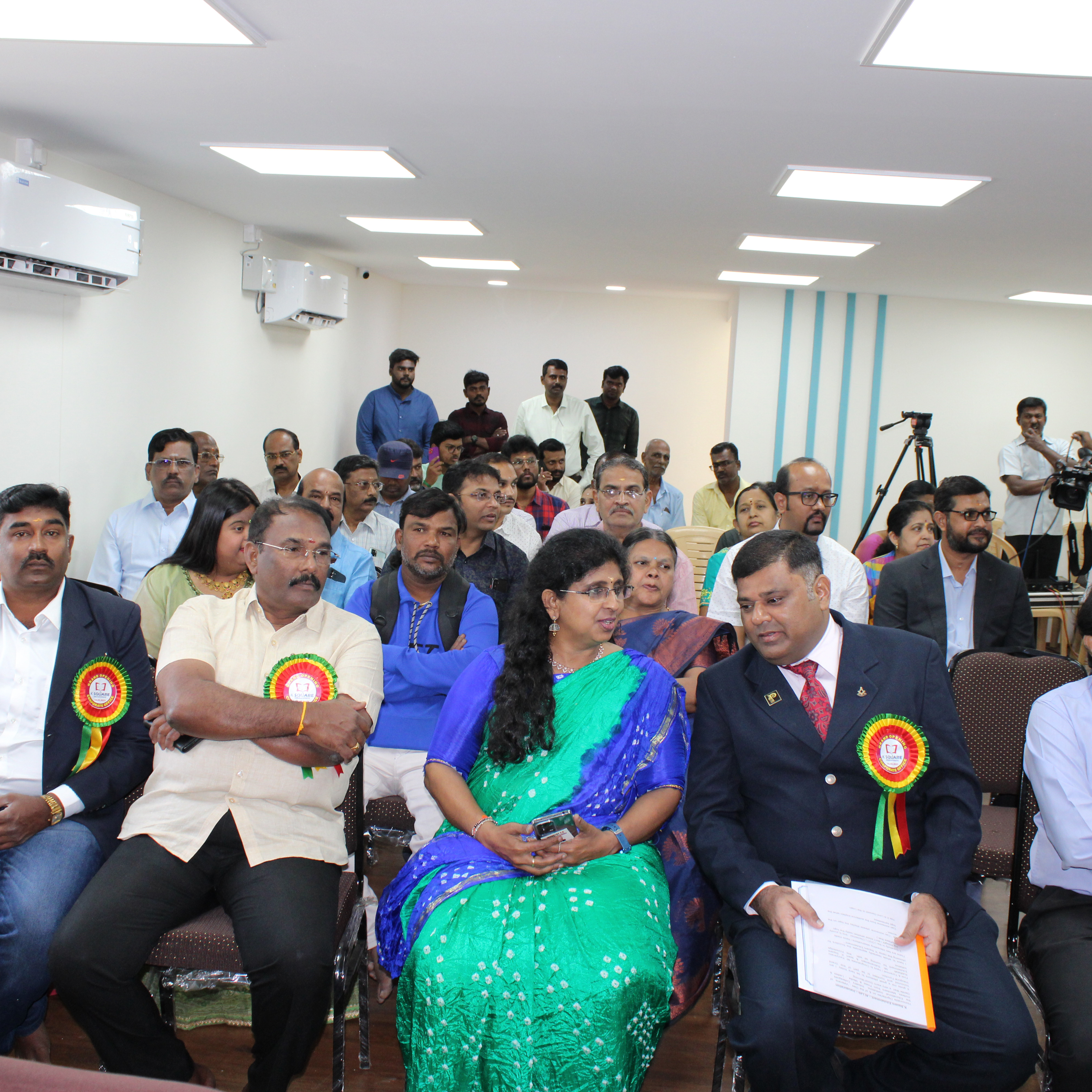 Several individuals seated in a K square edutainment conference room engaged in a meeting.