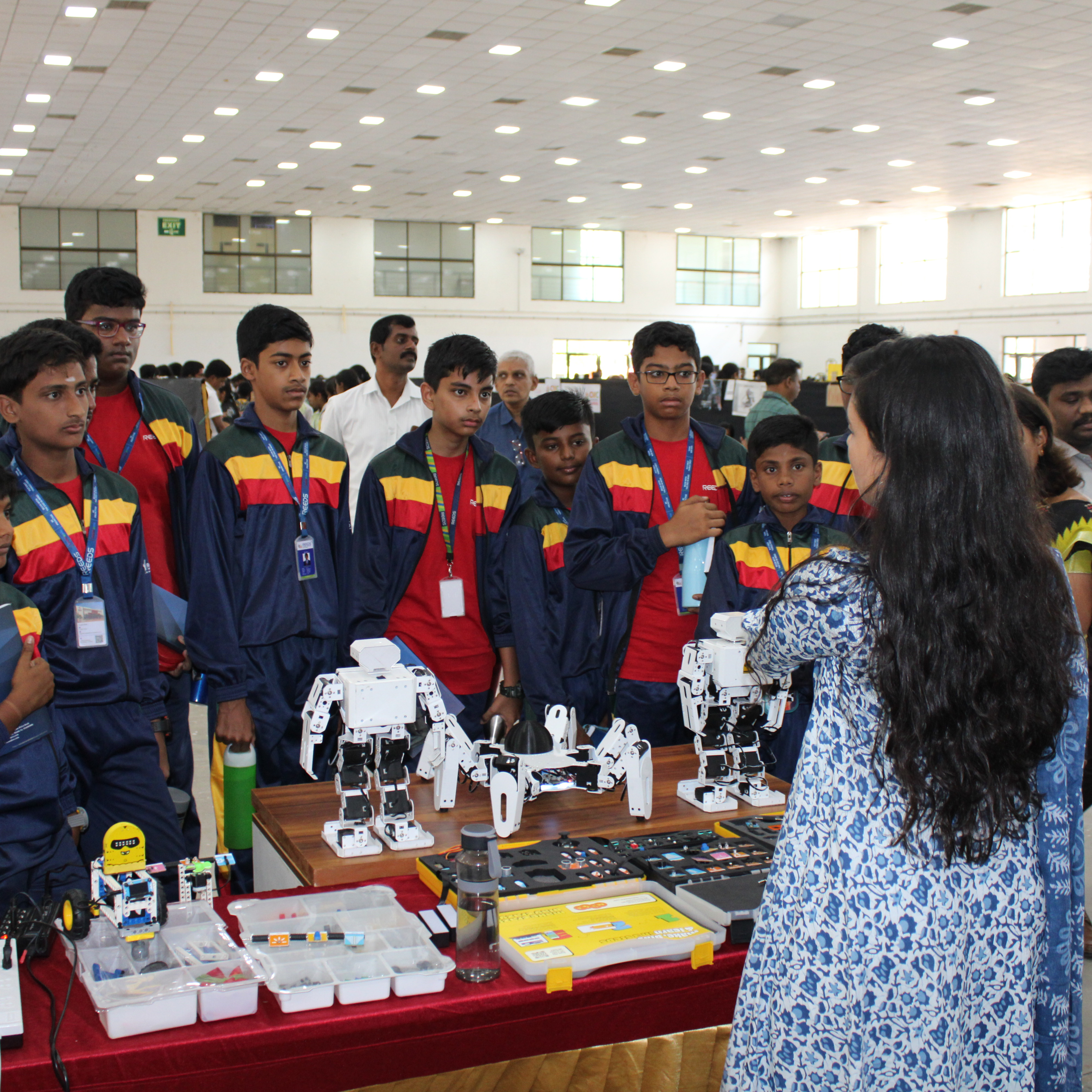 A diverse group of individuals gathered around a table and engaged in an exhibition.