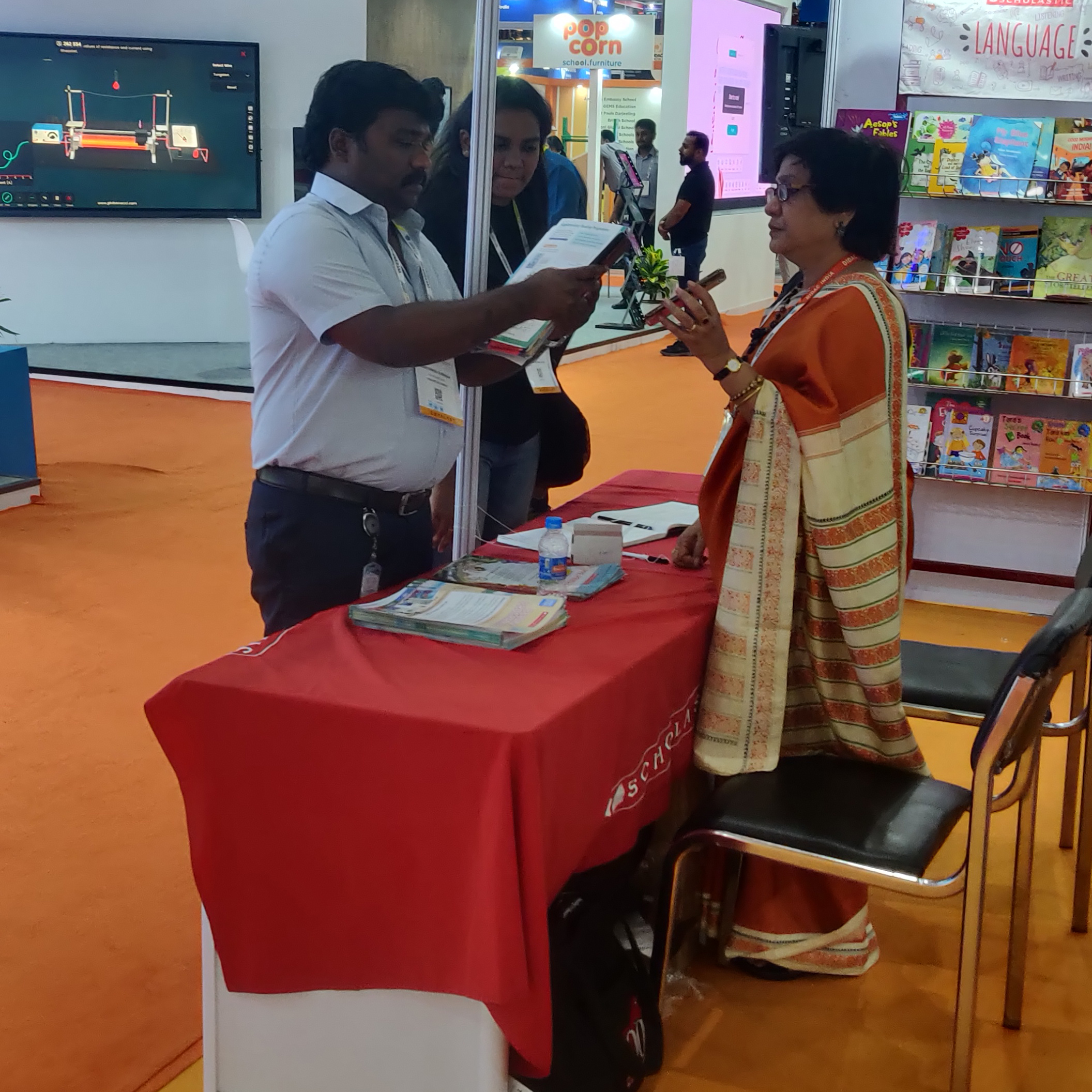 A man and woman standing at a table, discussing work together.