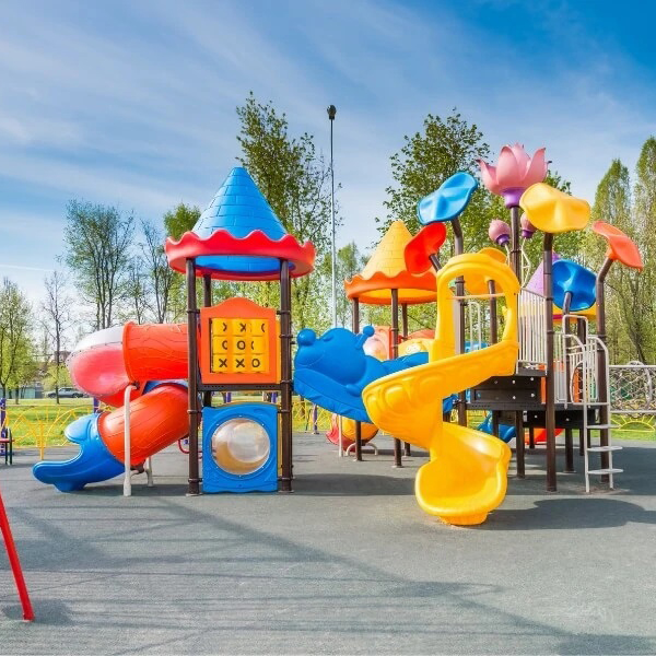 A vibrant playground with K square edutainment blue, red, yellow  slides and swings