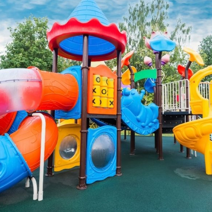 A vibrant playground with K square edutainment colorful slides and swings.